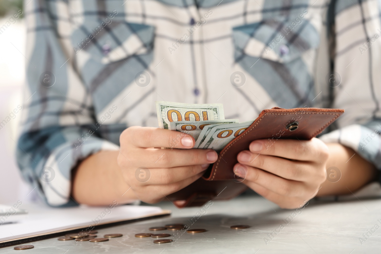 Photo of Woman counting money at light grey table, closeup