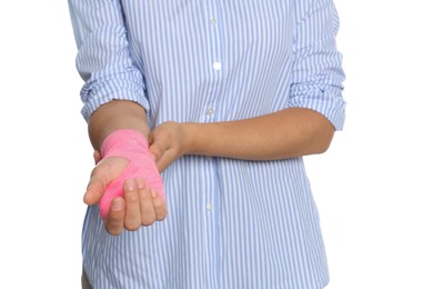 Young woman with hand wrapped in medical bandage on white background, closeup