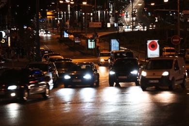 Photo of KYIV, UKRAINE - MAY 22, 2019: View of illuminated city street with road traffic