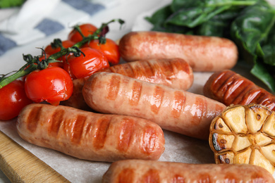 Photo of Delicious grilled sausages with vegetables served on table