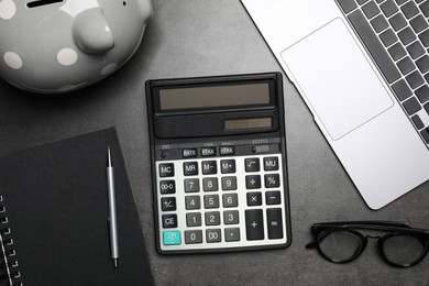 Flat lay composition with calculator on dark gray table