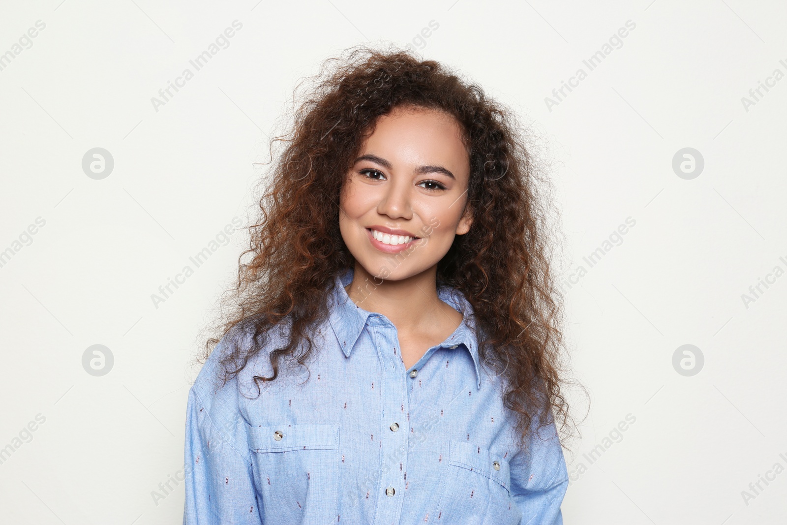 Photo of Young African-American woman with beautiful face on light background