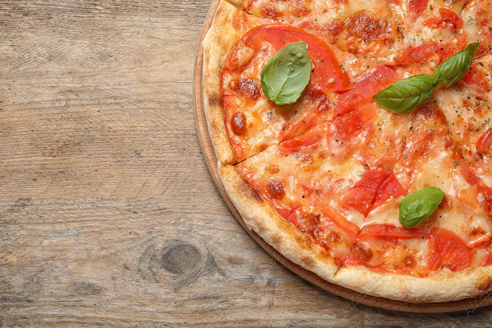 Photo of Delicious pizza Margherita on wooden table, top view. Space for text