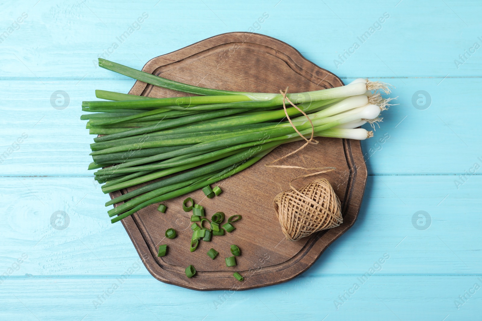 Photo of Composition with fresh green onions on light blue wooden background, top view