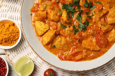 Delicious chicken curry and ingredients on table, top view