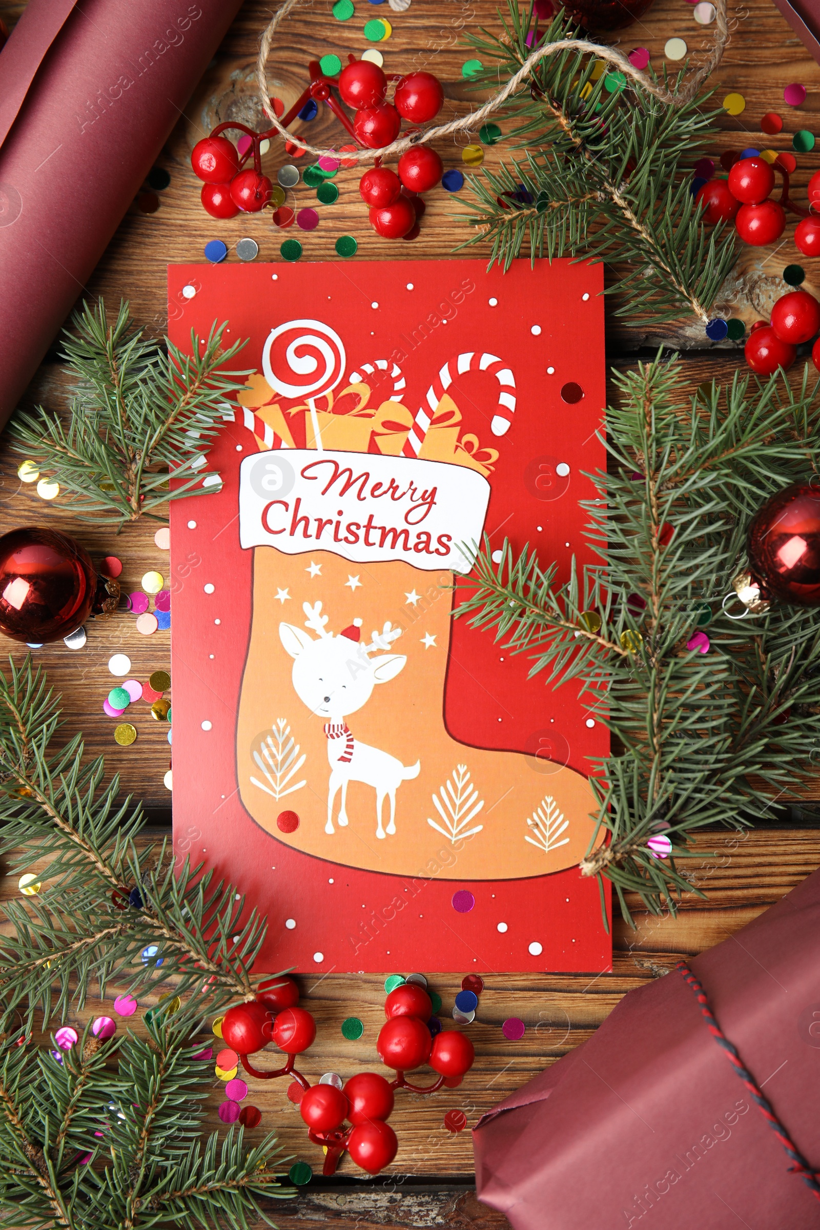 Photo of Flat lay composition with Christmas card and festive decor on wooden background