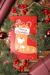 Photo of Flat lay composition with Christmas card and festive decor on wooden background
