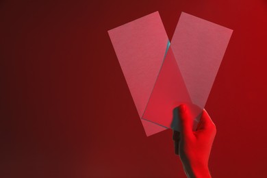 Man holding flyers on red background, closeup and space for text. Color tone effect
