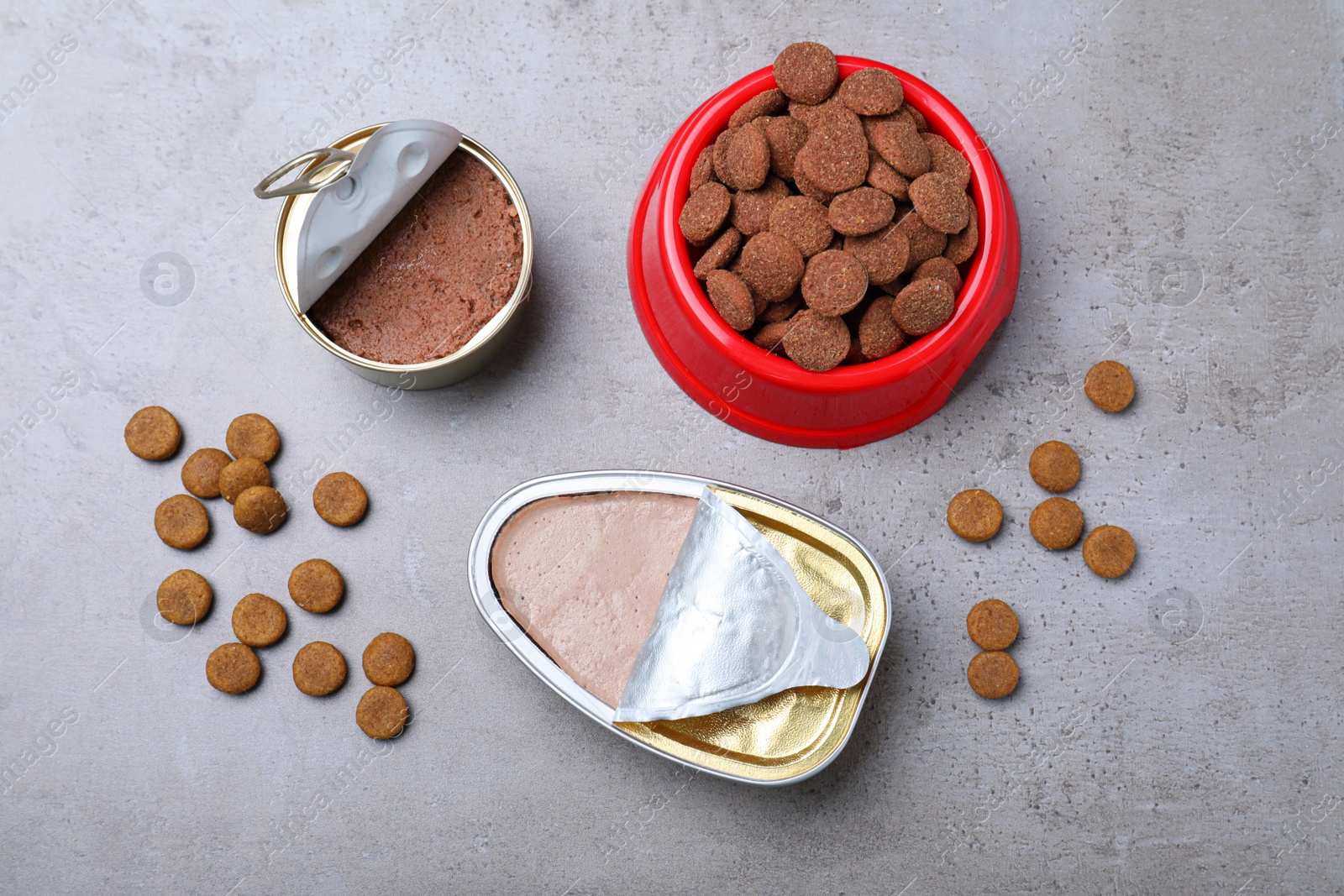 Photo of Wet and dry pet food on grey table, flat lay