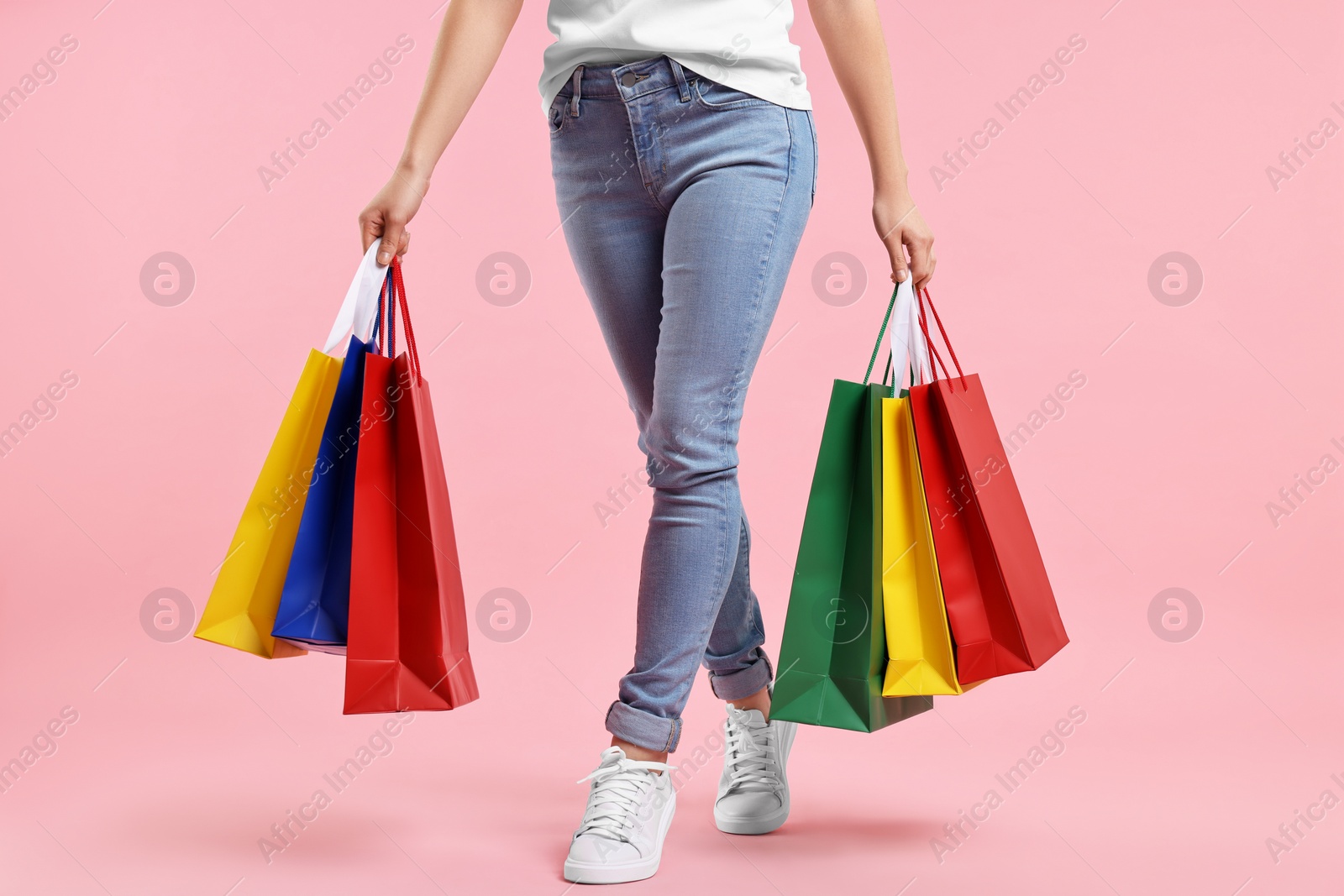 Photo of Woman with shopping bags on pink background, closeup
