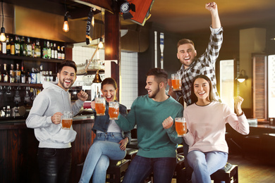 Group of friends watching football in sport bar