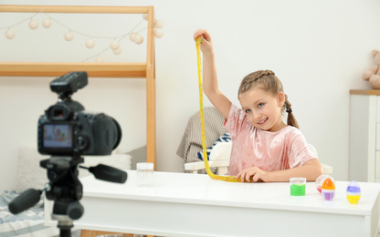 Cute little blogger with slime recording video at home