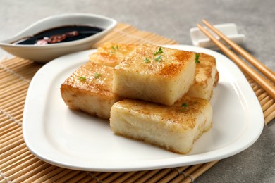 Photo of Plate with delicious turnip cake on grey table