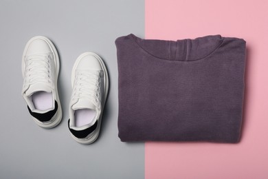 Photo of Garment and sport shoes on color background, flat lay
