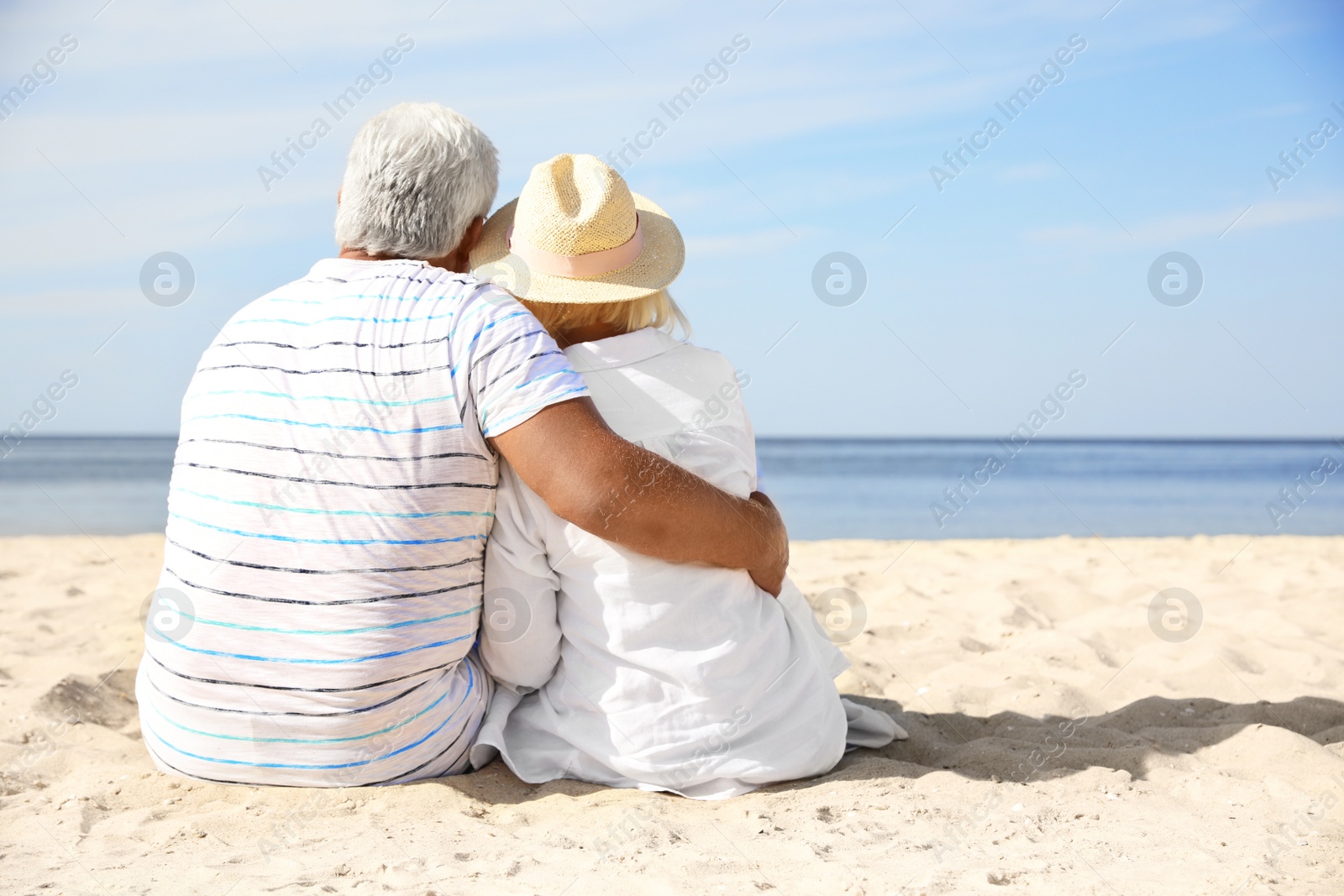 Photo of Mature couple spending time together on sea beach, back view