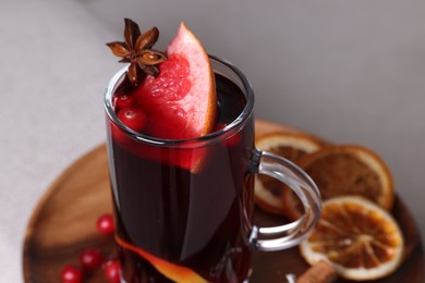 Aromatic mulled wine in glass cup on table, closeup