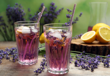 Photo of Fresh delicious lemonade with lavender and straws on wooden table