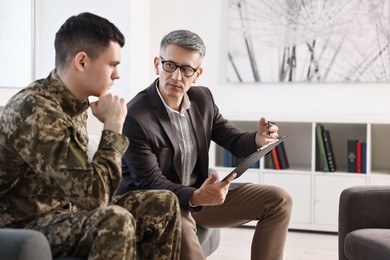 Photo of Professional psychotherapist working with military man in office