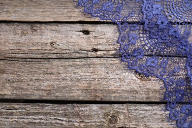 Photo of Beautiful lace on wooden table, top view. Space for text