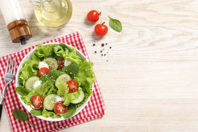 Delicious salad served on white wooden table, flat lay. Space for text