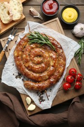 Photo of Delicious homemade sausage with spices served on wooden table, flat lay
