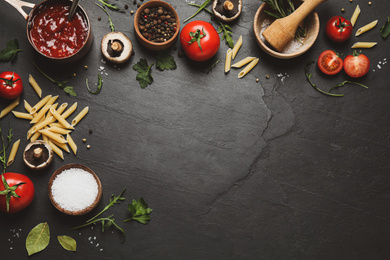 Flat lay composition with fresh products on black table, space for text. Healthy cooking