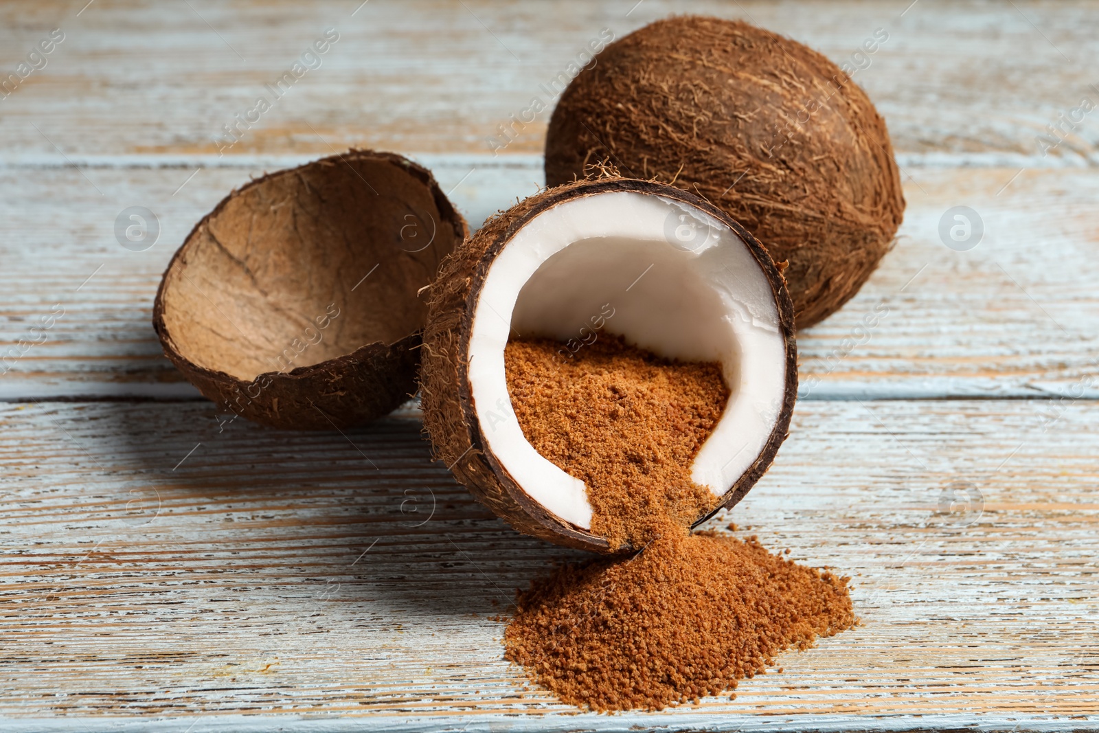 Photo of Ripe coconuts with natural brown sugar on rustic table