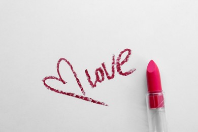 Red heart, word Love and lipstick on white background, top view