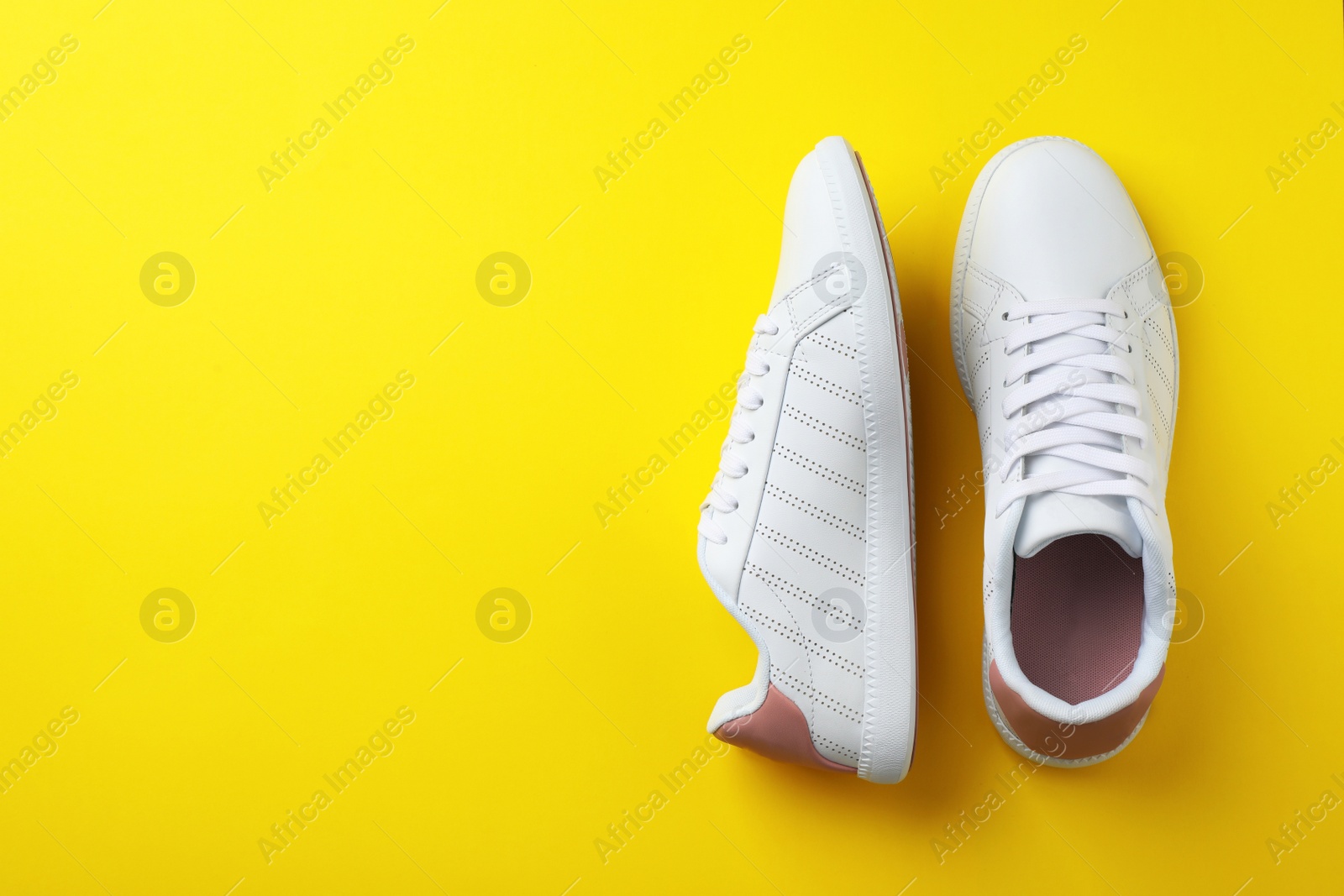 Photo of Pair of sneakers on color background, flat lay. Space for text