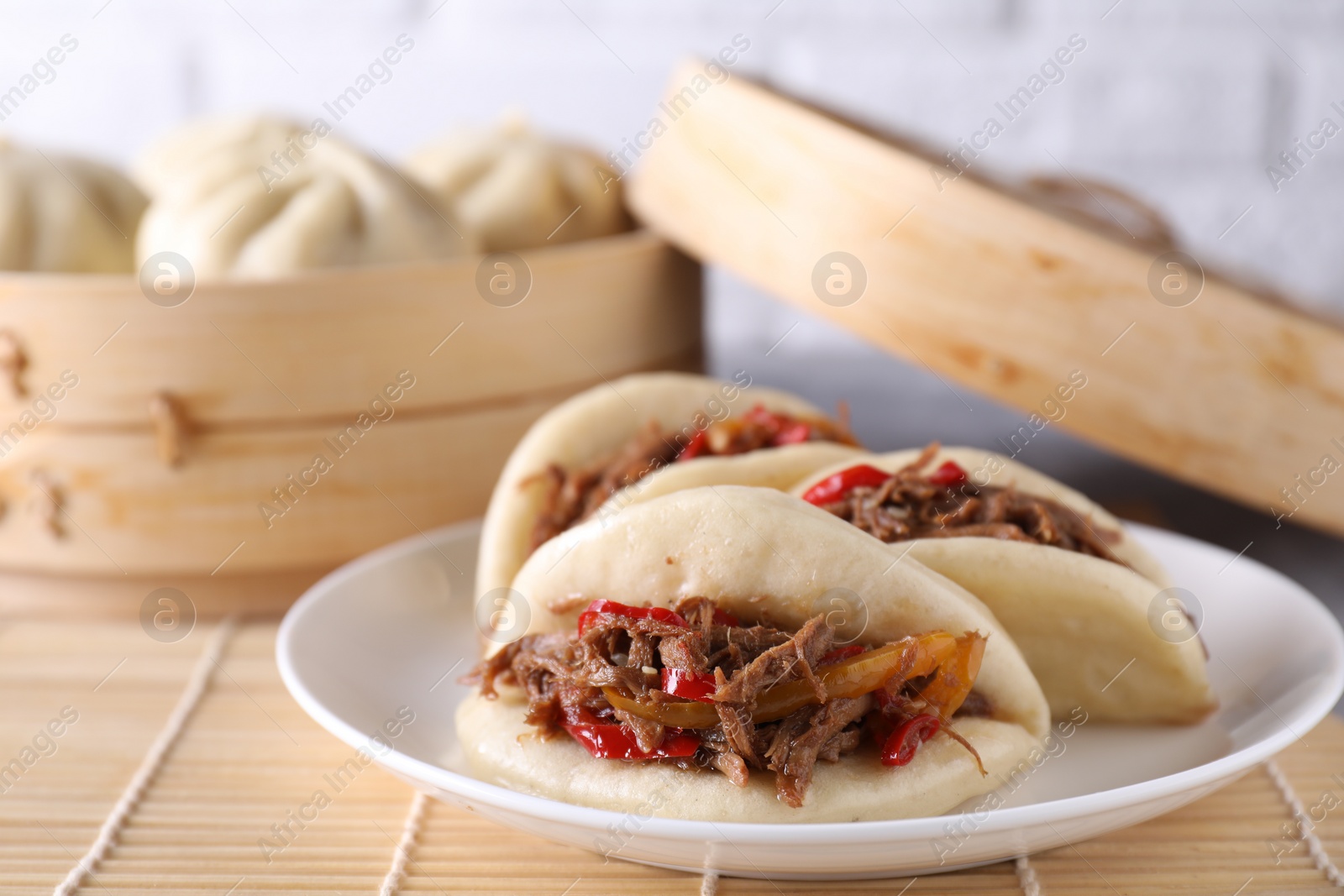 Photo of Plate with delicious gua bao (pork belly buns) on table, closeup