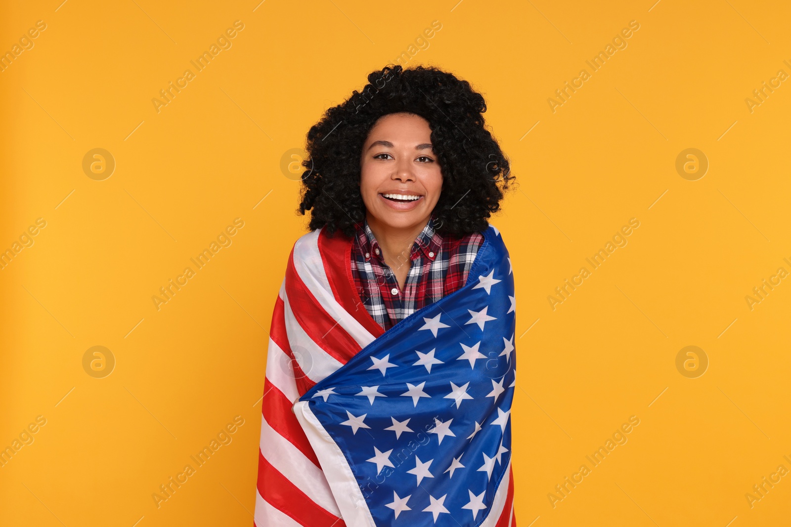 Photo of 4th of July - Independence Day of USA. Happy woman with American flag on yellow background