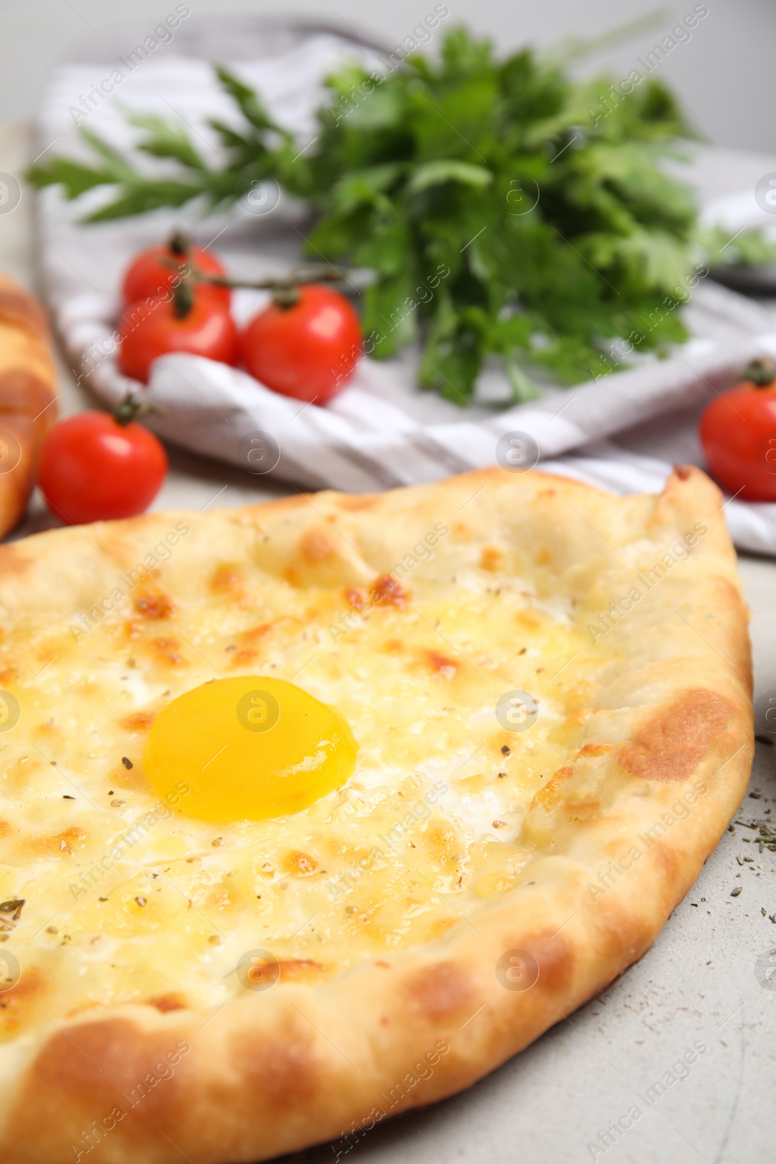 Photo of Fresh delicious Adjarian khachapuri on light table, closeup