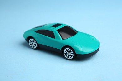 Photo of One bright car on light blue background. Children`s toy