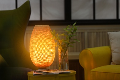 Photo of Stylish lamp on table in living room. Interior design element