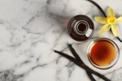 Photo of Homemade vanilla extract on marble table, flat lay. Space for text