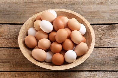 Chicken eggs in bowl on wooden table