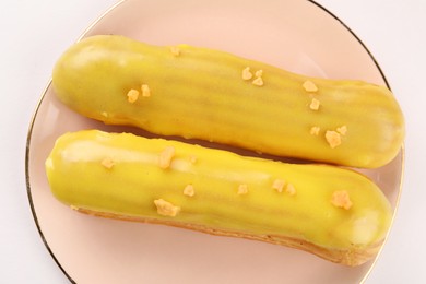 Photo of Delicious eclairs covered with glaze on white background, top view