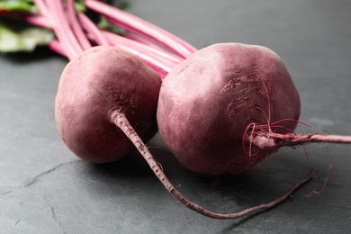 Raw ripe beets on black slate table, closeup