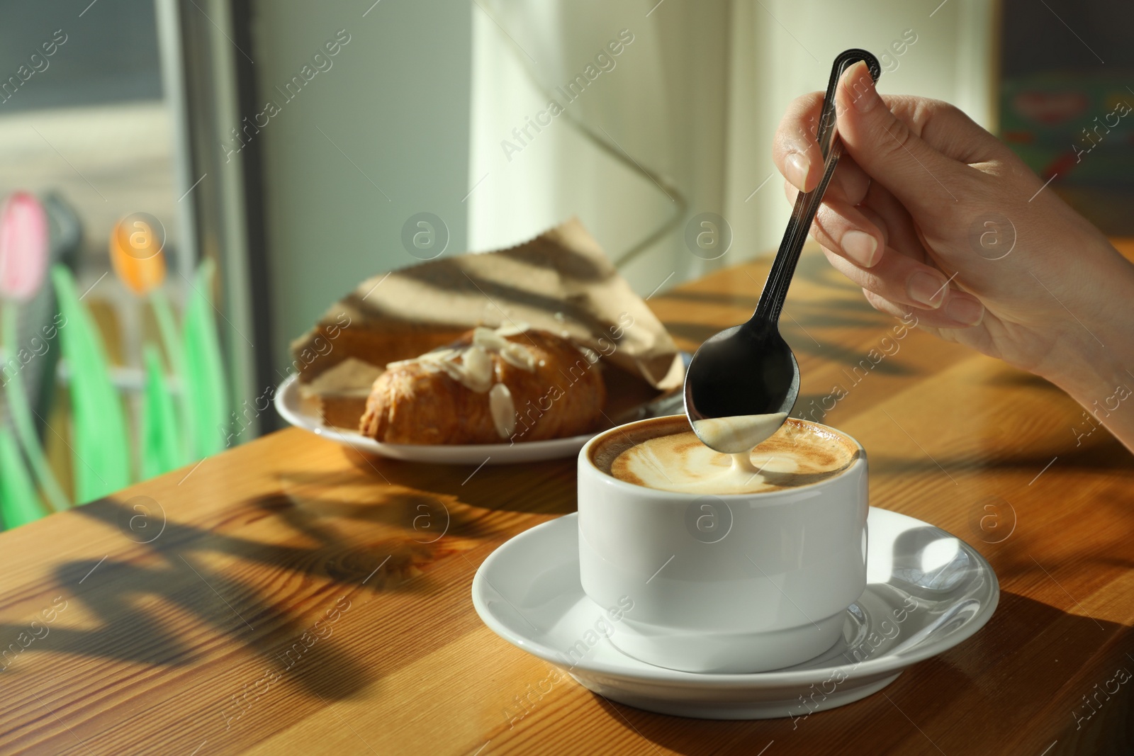 Photo of Woman with cup of fresh aromatic coffee at table in cafe