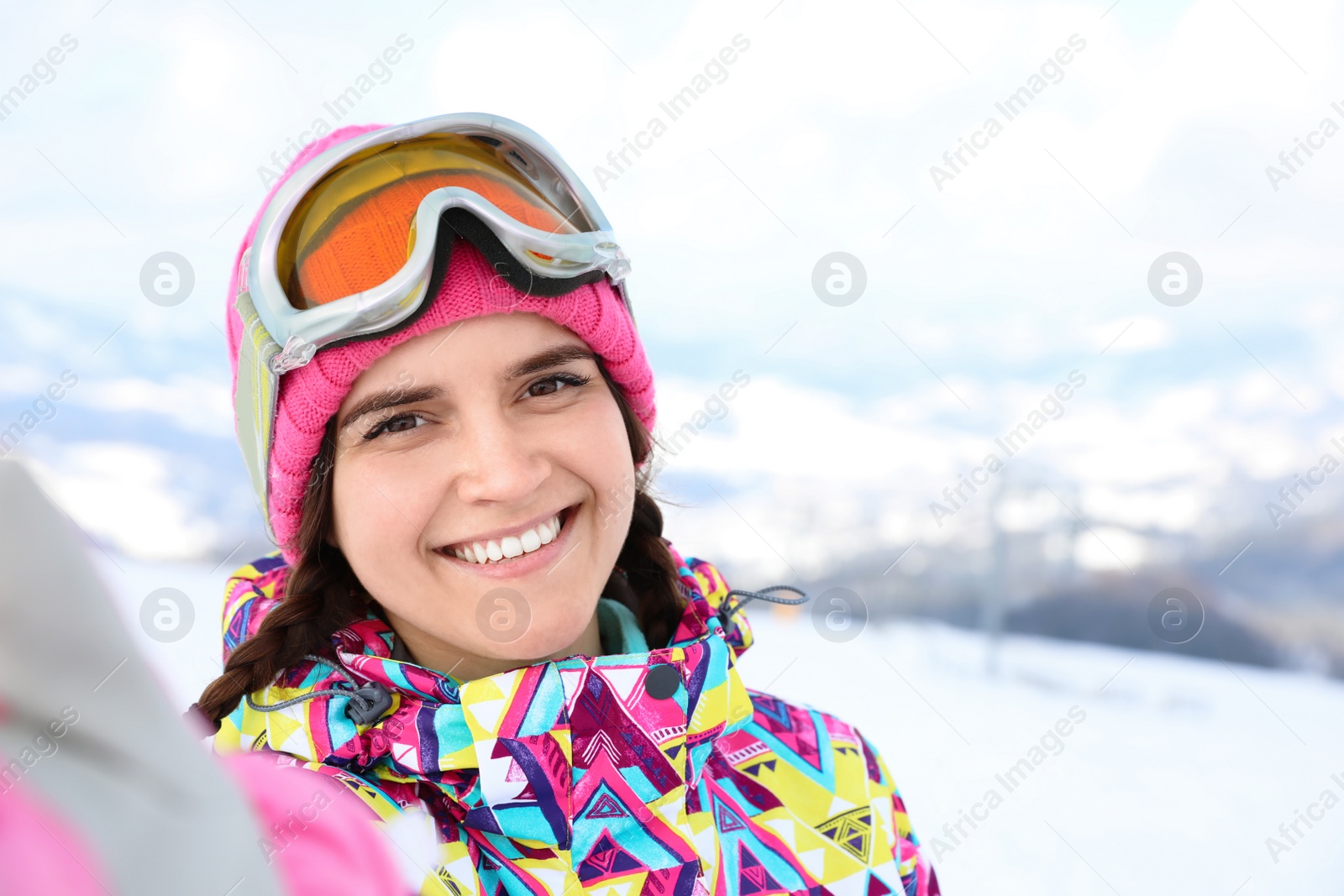 Photo of Young woman taking selfie at mountain resort. Winter vacation