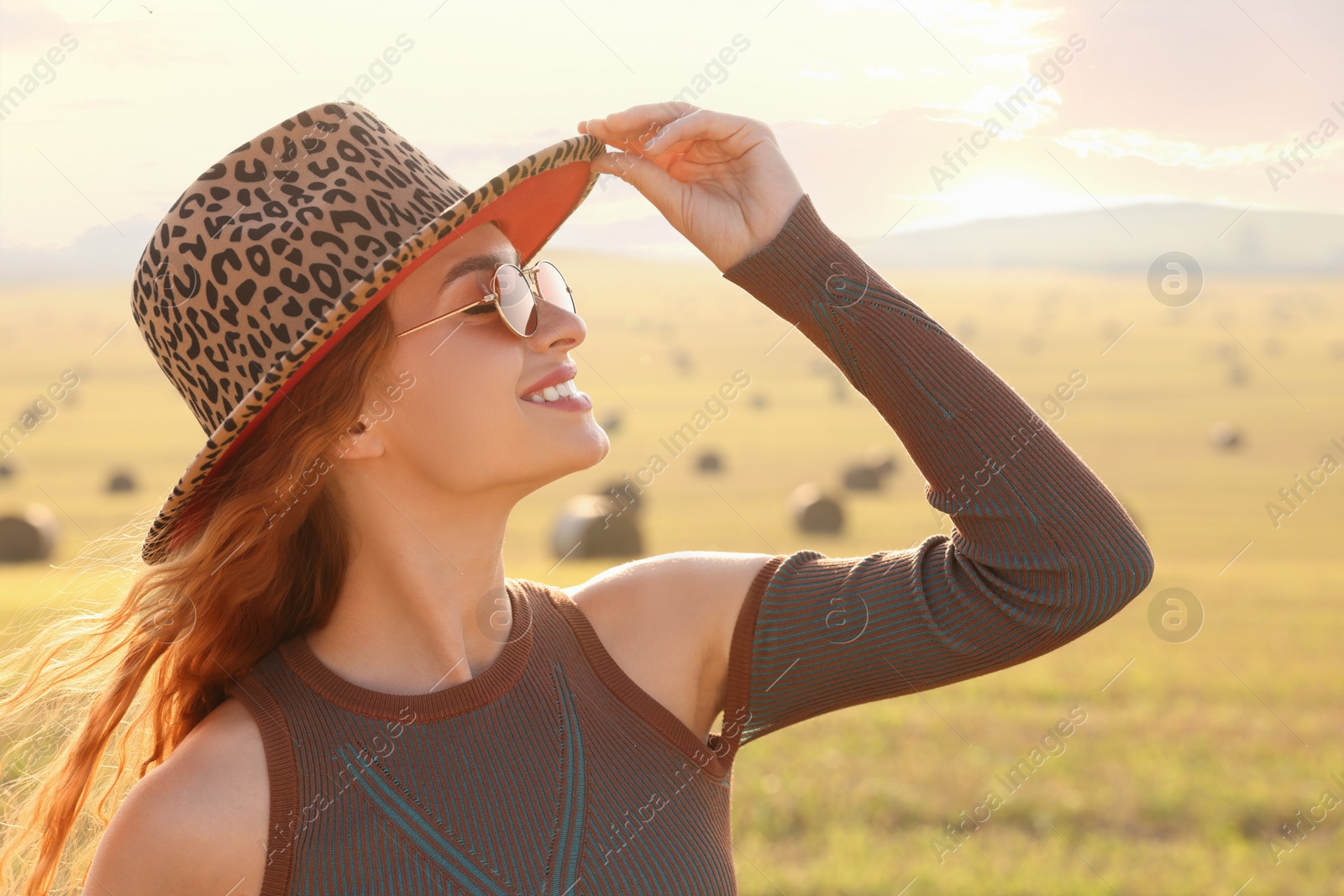 Photo of Beautiful happy hippie woman in hat in field