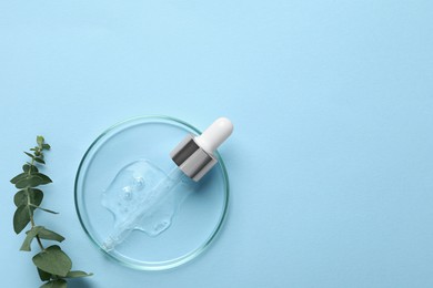 Petri dish with sample of cosmetic oil, pipette and eucalyptus branch on light blue background, flat lay. Space for text