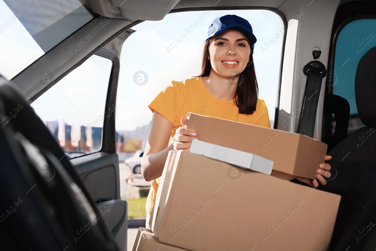 Photo of Courier taking parcel from car. Delivery service