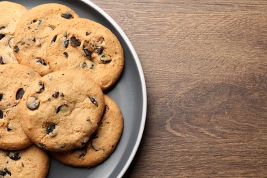 Delicious chocolate chip cookies on wooden table, top view. Space for text
