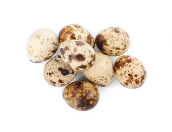Many speckled quail eggs on white background, top view