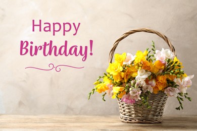 Image of Happy Birthday! Beautiful freesia flowers in wicker basket on table  