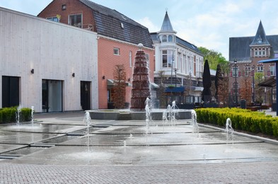 Photo of City street with modern fountain and beautiful buildings