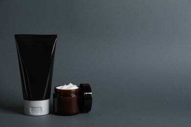 Photo of Tube and jar of men's facial creams on grey background. Mockup for design