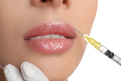 Photo of Woman getting lip injection on white background, closeup