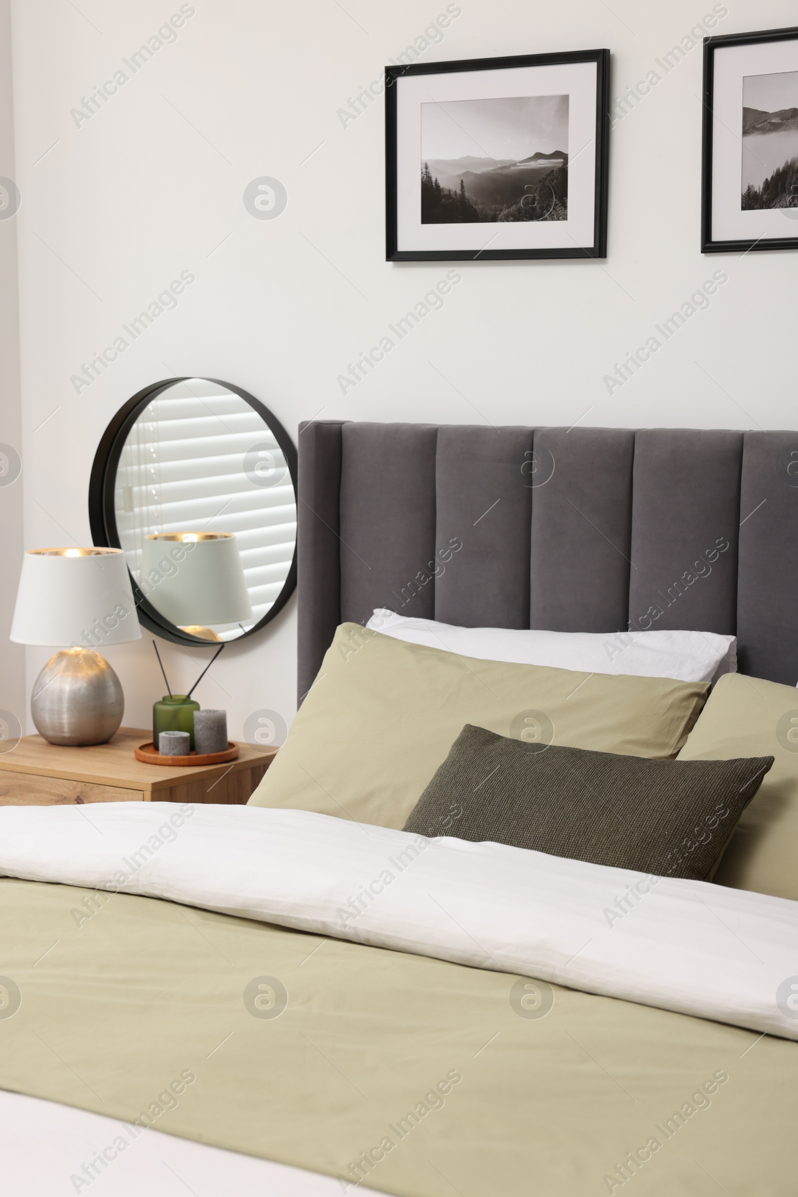 Photo of Comfortable bed with soft pillows and blanket in bedroom